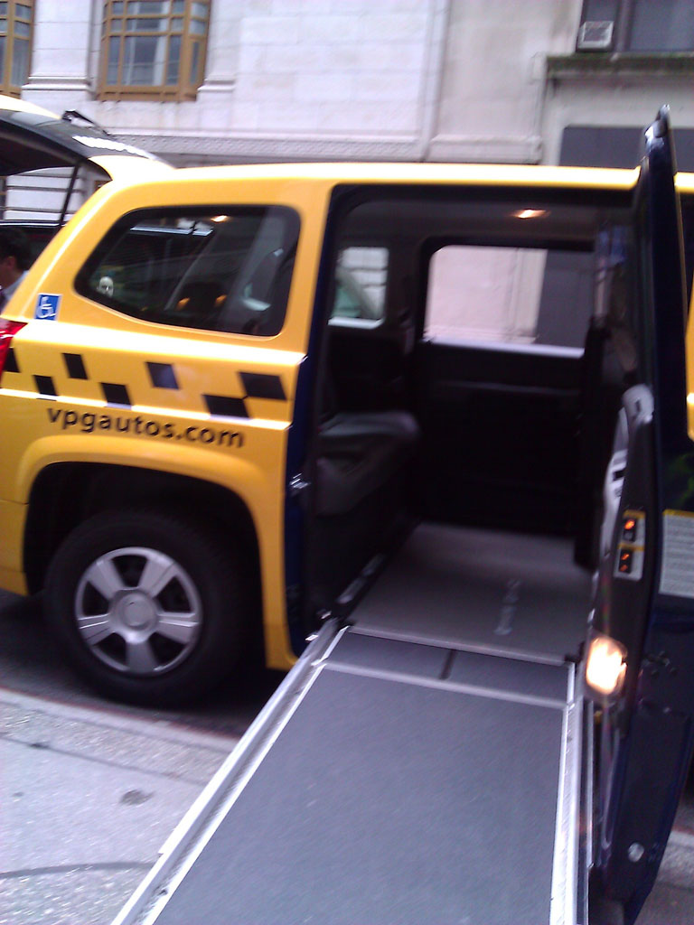 larger photo of a ramp extended outside of a yellow Nissan MV-1