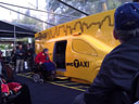 photo of Taxi of Tomorrow displayed under a plastic tent